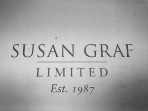 Black and white image of a sign that reads "Susan Graf Limited Est. 1987" in uppercase and serif font.